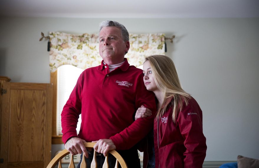 ADVANCE FOR USE WEDNESDAY, APRIL 19, 2017 AND THEREAFTER-Rick Rodrigue, left, stands with his daughter Stephanie, 17, at their home in Lewiston, Maine, Thursday, March 16, 2017. His daughter attends Lewiston High School where students speak dozens of languages, and hail from dozens of nations: Somalia, Djibouti, Congo, Yemen. "It will help her in life," Rodrigue says. "The world is not all white." Yet in November 2016, Rodrigue voted for Donald Trump. Rodrigue's reasoning: America is struggling, and America needs to take care of its own before it takes care of anyone else. (AP Photo/David Goldman)
