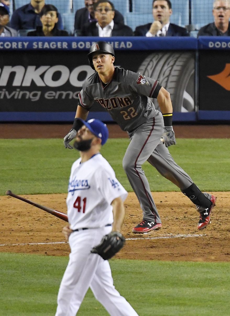 Arizona Diamondbacks' Jake Lamb, right, hits a solo home run as Los Angeles Dodgers relief pitcher Chris Hatcher watches during the eighth inning of a baseball game, Monday, April 17, 2017, in Los Angeles. (AP Photo/Mark J. Terrill)