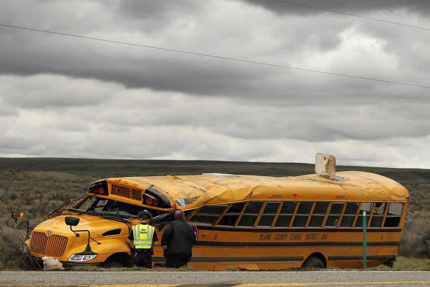 Emergency personnel work at the scene of a school bus crash Tuesday, April 18, 2017, west of Richfield, Idaho. At least 17 students have been taken to hospitals, some with serious injuries, after a bus carrying 39 students to a track meet rolled over on a rural stretch of road in central Idaho. (Drew Nash/The Times-News via AP)