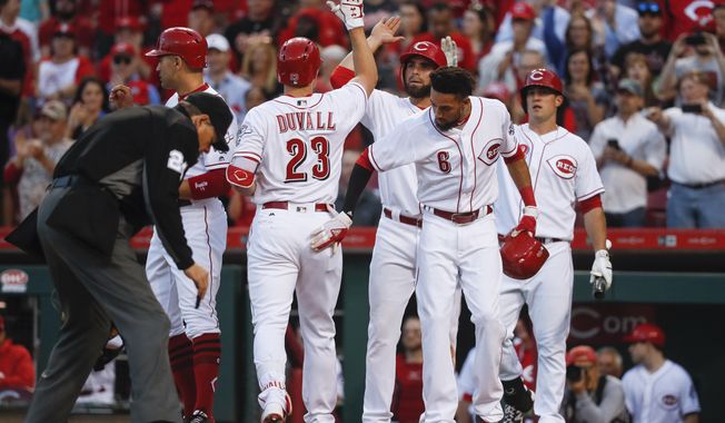 Cincinnati Reds&#x27; Adam Duvall (23) celebrates with Joey Votto, left, Jose Peraza, center right, and Billy Hamilton (6) after hitting a grand slam off Baltimore Orioles starting pitcher Kevin Gausman in the second inning of a baseball game, Tuesday, April 18, 2017, in Cincinnati. (AP Photo/John Minchillo)