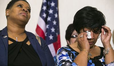 The widow of slain Lt. Steven Floyd Sr. wipes the tears from her eyes as her attorney announces the filing of a federal lawsuit against former governors Jack Markell, Ruth Ann Minner and others seeking compensatory and punitive damages after a prison riot at the Vaughn Correctional Center in Smyrna, Del. (Suchat Pederson/The Wilmington News-Journal via AP)