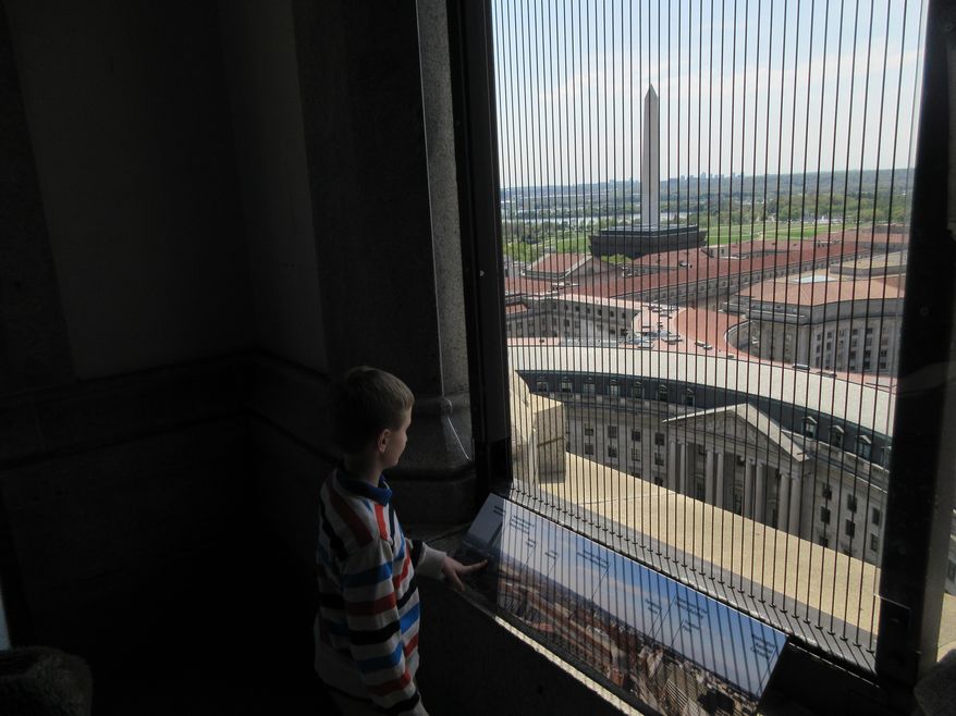 This April 13, 2017 image shows a visitor taking in views from the clock tower at the Old Post Office, a historic building in Washington D.C., where the Trump International Hotel is located. The clock tower is operated by the National Park Service and was recently reopened to the public for tours. (AP Photos/Beth J. Harpaz)