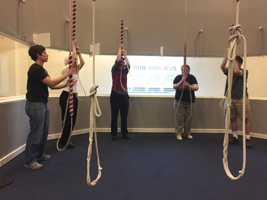 This April 13, 2017 photo shows members of the Washington Ringing Society ringing bells during their weekly rehearsal in the clock tower at the Old Post Office in Washington, D.C. The bells are formally rung to mark national holidays and at the opening and closing of Congress. The clock tower recently reopened to tours and tower visitors can see the colorful ropes the bell-ringers pull to sound the bells but not the bells themselves, though plans are in the works to open a viewing area for the bells as well. (AP Photos/Beth J. Harpaz)