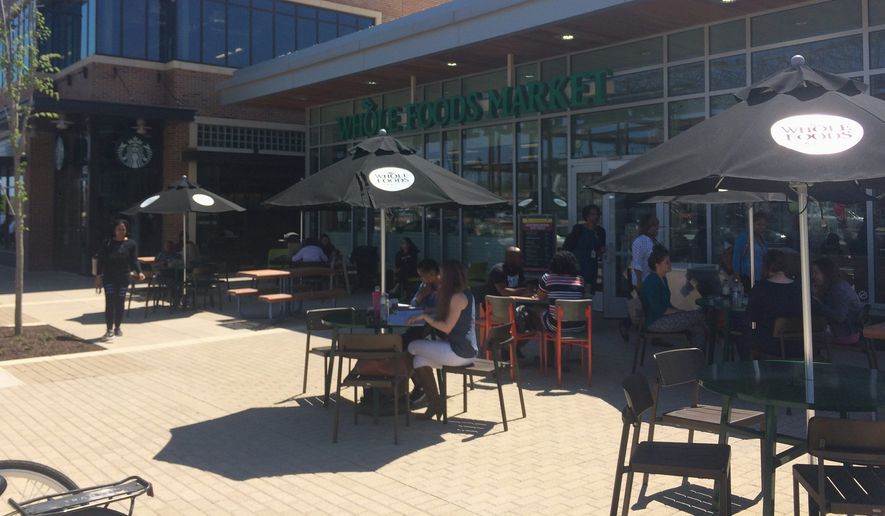 Customers dine at the Whole Foods market cafe in the new Riverdale Park Station shopping center. The store opened April 12 after six years fraught with delays. (Julia Brouillette/The Washington Times)