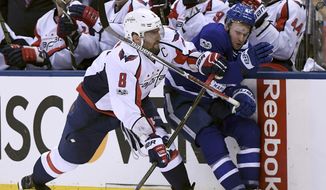 Washington Capitals left wing Alex Ovechkin (8) sends Toronto Maple Leafs centre Tyler Bozak (42) to the boards during second period NHL hockey round one playoff action in Toronto on Wednesday, April 19, 2017. (Frank Gunn/The Canadian Press via AP)