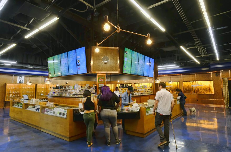 In this April 15, 2017, photo customers get help at the ShowGrow, a medical marijuana dispensary in downtown Los Angeles. This year is poised to be a big one for legalized marijuana, with California and other states that recently approved recreational pot coming online. Yet uncertainty over the Trump administration's intents toward pot enforcement has created at least partial paralysis in those states on public consumption, licensing and other issues. (AP Photo/Richard Vogel)