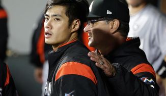 Miami Marlins starting pitcher Wei-Yin Chen, left, is pulled after the seventh inning of a baseball game against the Seattle Mariners by manager Don Mattingly, right, Tuesday, April 18, 2017, in Seattle. (AP Photo/Ted S. Warren)