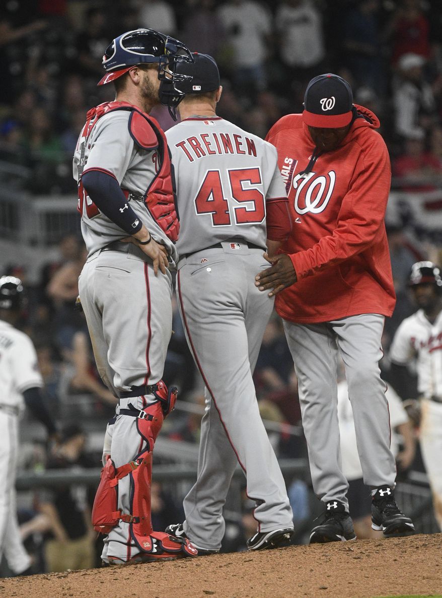 Washington Nationals pitcher Blake Treinen (45) is pulled from the baseball game by manager Dusty Baker, right, as catcher Matt Wieters stands by, after the Atlanta Braves loaded the bases during the ninth inning Tuesday, April 18, 2017, in Atlanta. Washington won 3-1. (AP Photo/John Amis)