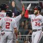Washington Nationals&#39; Bryce Harper gets high-fives at home hitting a grand slam off Atlanta Braves pitcher Julio Jones during the second inning of a baseball game Wednesday, April 19, 2017, in Atlanta. Harper had a solo homer in the first inning. (Curtis Compton/Atlanta Journal-Constitution via AP)