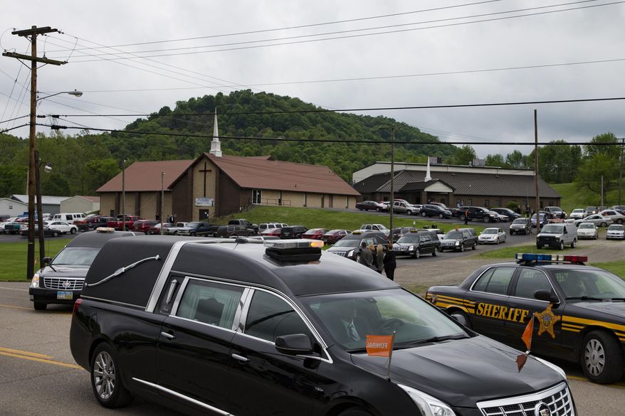 FILE – In this May 3, 2016, file photo, hearses for six of the eight members of the Rhoden family found shot April 22, 2016, at four properties near Piketon, Ohio, depart during funeral services from Dry Run Church of Christ in West Portsmouth, Ohio. The Ohio Supreme Court on Wednesday, April 19, 2017, ordered the Pike County coroner to submit unredacted autopsy reports from the unsolved slayings for justices to review outside of public view, as the court considers media lawsuits seeking access to those full reports. (AP Photo/John Minchillo, File)