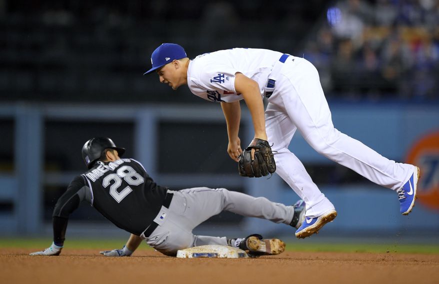 Colorado Rockies' Nolan Arenado, left, slides into second for a double under the tag of Los Angeles Dodgers shortstop Corey Seager during the third inning of a baseball game, Tuesday, April 18, 2017, in Los Angeles. (AP Photo/Mark J. Terrill)