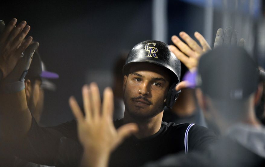 Colorado Rockies' Nolan Arenado is congratulated by teammates after hitting a solo home run during the fifth inning of the teams baseball game against the Los Angeles Dodgers, Tuesday, April 18, 2017, in Los Angeles. (AP Photo/Mark J. Terrill)