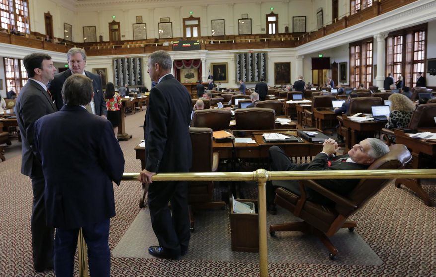 Rep. Dan Huberty, R-Houston, right, sits at his desk on the house floor Wednesday, April 19, 2017, in Austin, Texas. Huberty, Chair of the House Public Education Committee, is the sponsor of House Bill 21 which would put money into the school system. (AP Photo/Eric Gay)