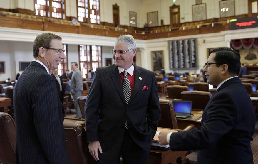 Rep. Dan Huberty, R-Houston, center, talks with Rep. Byron Cook, R-Corsicana, left, and Rep. Diego Bernal, D-San Antonio, right, on the house floor Wednesday, April 19, 2017, in Austin, Texas. Huberty, Chair of the House Public Education Committee, is the sponsor of House Bill 21 which would put money into the school system. (AP Photo/Eric Gay)