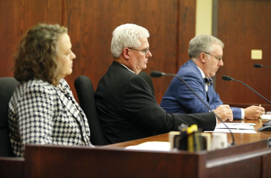 Commissioner Shari Albrecht, left, Chairman Pat Apple, center, and Commissioner Jay Emler, of the Kansas Corporation Commission unanimously voted down the approval of a merger on Wednesday, April 19, 2017, in Topeka, Kan., between Westar Energy and Great Plains. (Chris Neal/The Topeka Capital-Journal via AP)