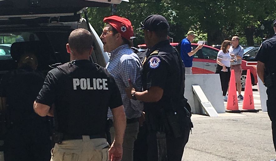 Police arrest DCMJ co-founder Adam Eidinger for distributing marijuana across the street from the U.S. Capitol on Thursday. (The Washington Times/Laura Kelly)