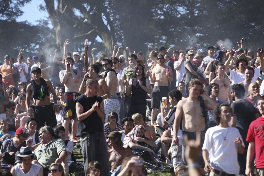 FILE - In this April 20, 2009, file photo, a large crowd cheers as the time reaches 4:20 p.m. on Hippie Hill in Golden Gate Park in San Francisco. Thursday, April 20, 2017, marks marijuana culture’s high holiday, 4/20, when college students gather - at 4:20 p.m. - in clouds of smoke on campus quads and pot shops in legal weed states thank their customers with discounts. (AP Photo/Jeff Chiu, File)