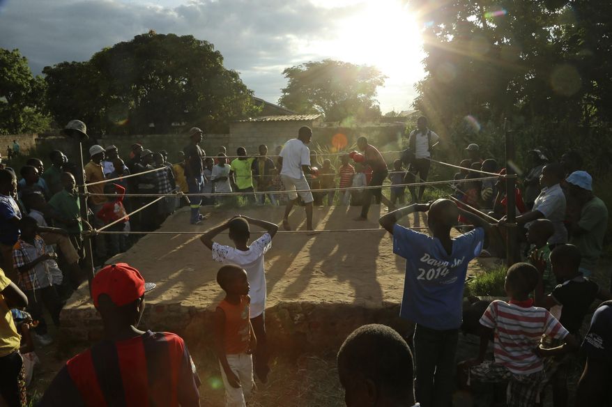 In this Saturday, Feb. 12, 2017 photo, young boys fight in a boxing ring in Chitungwiza, Zimbabwe. Zimbabwean boys as young as 10 hurry every weekend to a boxing ring whose nickname, Wafa Wafa, in the local Shona language suggests that whoever enters will be lucky to come out alive. (AP Photo/Tsvangirayi Mukwazhi)
