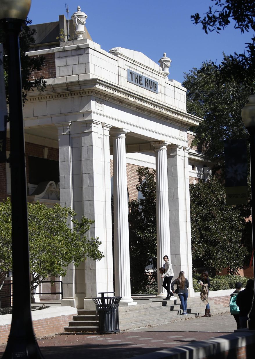 In this Nov. 21, 2016 photograph, students walk across the University of Southern Mississippi campus in Hattiesburg, Miss. Tuition and fees would rise at Mississippi's eight public universities in fall 2017- under changes approved Thursday, April 20, 2017, by the College Board. (AP Photo/Rogelio V. Solis)