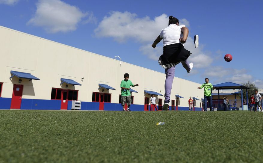 FILE - In this Sept. 10, 2014, file photo, children play kickball at the Karnes County Residential Center, a temporary home for immigrant women and children detained at the border, in Karnes City, Texas. A recent promise by President Donald Trump's administration not to separate most parents and children who are stopped crossing the U.S.-Mexico border means the government will need space to hold them, but the only three spaces equipped to house families, one in Pennsylvania and two in Texas, are having trouble getting licensed as childcare facilities. (AP Photo/Eric Gay, File)