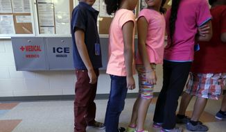 In this Sept. 10, 2014, file photo, detained immigrant children line up in the cafeteria at the Karnes County Residential Center, a temporary home for immigrant women and children detained at the border, in Karnes City, Texas. (AP Photo/Eric Gay, File)