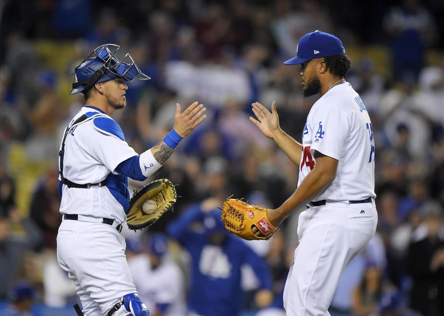 Los Angeles Dodgers relief pitcher Kenley Jansen, right, is congratulated by catcher Yasmani Grandal after the Dodgers defeated the Colorado Rockies 4-2 in a baseball game, Wednesday, April 19, 2017, in Los Angeles. (AP Photo/Mark J. Terrill)