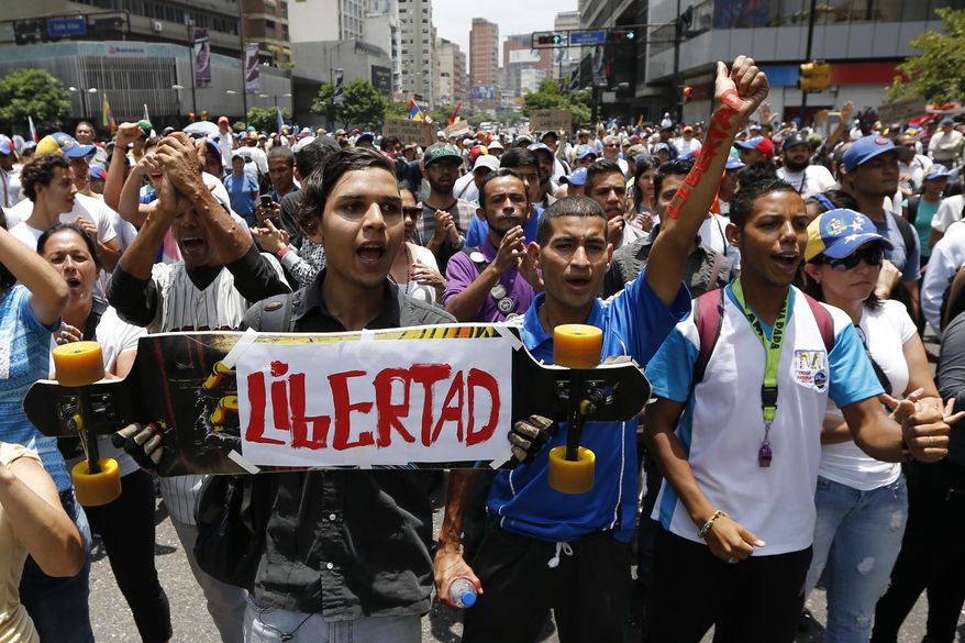 Opponents of President Nicolas Maduro march in Caracas, Venezuela, Thursday, April 20, 2017. Tens of thousands of protesters flooded the streets again Thursday, one day after three people were killed and hundreds arrested in the biggest anti-government demonstrations in years. (AP Photo/Ariana Cubillos)