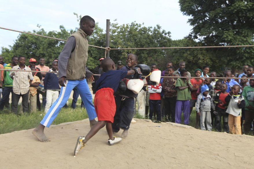 In this Sunday, March 11, 2017 photo, children fight in a boxing ring in Chitungwiza, Zimbabwe. Zimbabwean boys as young as 10 hurry every weekend to a boxing ring whose nickname, Wafa Wafa, in the local Shona language suggests that whoever enters will be lucky to come out alive. (AP Photo/Tsvangirayi Mukwazhi)