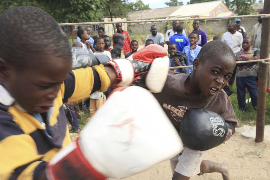 In this Sunday, March 11, 2017 photo, children fight in a boxing ring in Chitungwiza, Zimbabwe. Zimbabwean boys as young as 10 hurry every weekend to a boxing ring whose nickname, Wafa Wafa, in the local Shona language suggests that whoever enters will be lucky to come out alive. (AP Photo/Tsvangirayi Mukwazhi)