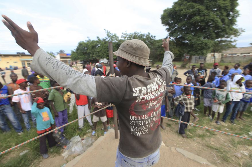In this Sunday, March 11, 2017 photo, a referee invites young boys into the boxing ring in Chitungwiza, Zimbabwe. Zimbabwean boys as young as 10 hurry every weekend to a boxing ring whose nickname, Wafa Wafa, in the local Shona language suggests that whoever enters will be lucky to come out alive. (AP Photo/Tsvangirayi Mukwazhi)