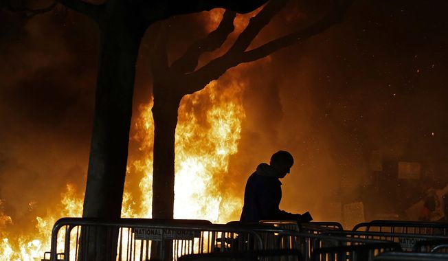 In this Feb. 1, 2017 file photo, a fire set by demonstrators protesting a scheduled speaking appearance by Breitbart News editor Milo Yiannopoulos burns on Sproul Plaza on the University of California, Berkeley campus. (AP Photo/Ben Margot, File)