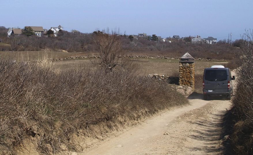 In this Tuesday, April 11, 2017 photo, Vin McAloon drives his taxi down a road in New Shoreham, R.I. The town's taxi rules include a surcharge for driving on dirt roads. McAloon, Block Island's retired police chief, drives one of the two taxis that operate year-round on the island. (AP Photo/Matt O'Brien)