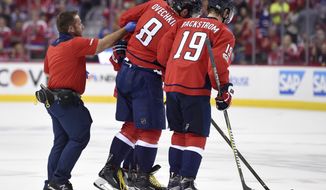 Washington Capitals left wing Alex Ovechkin (8), of Russia, is helped off the ice by a trainer and Nicklas Backstrom (19), of Sweden, after he was injured during the first period of Game 5 in an NHL Stanley Cup hockey first-round playoff series against the Toronto Maple Leafs, Friday, April 21, 2017, in Washington. (AP Photo/Nick Wass)