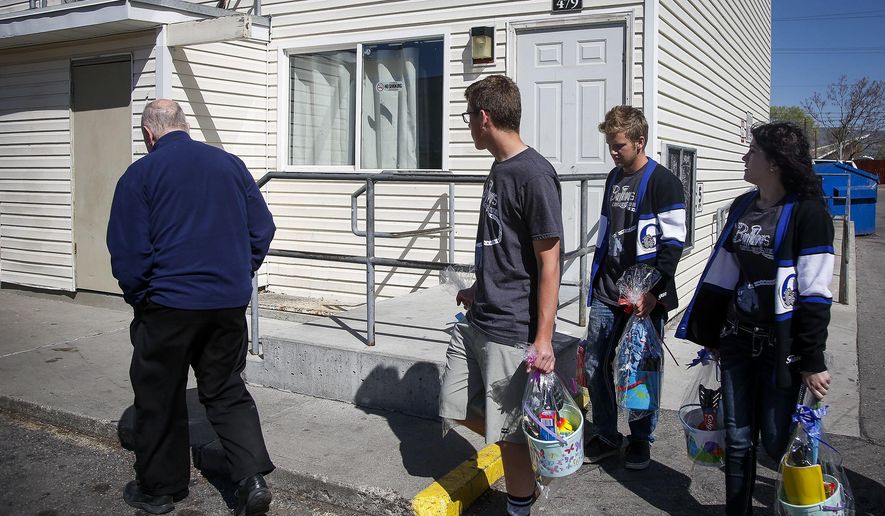 In this Thursday, April 13, 2017 photo, students from Gunnison Valley High School, organized by Don Ward, left, a retired high school history teacher, hand out Easter baskets to refugees in the South Parc Apartments in South Salt Lake, Utah. When the LDS Church launched its "I Was a Stranger" initiative last year, Ward couldn't help but smile because people were suddenly motivated and wanted to get involved. The Deseret News reported people were unaware that there are 60,000 refugees in Utah. Ward estimated that he and others have helped more than 20,000 refugees in Salt Lake County over the past eight years. (Nicole Boliaux/The Deseret News via AP)