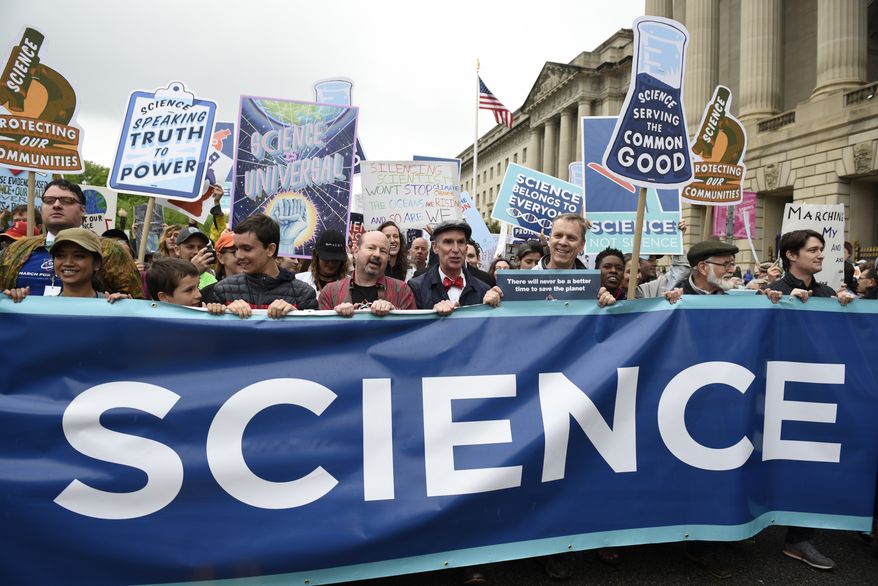 People carry a banner and signs as they pass the U.S. Environmental Protection Agency during the March For Science in Washington, Saturday, April 22, 2017. Scientists, students and research advocates rallied from the Brandenburg Gate to the Washington Monument on Earth Day, conveying a global message of scientific freedom without political interference and spending necessary to make future breakthroughs possible. (AP Photo/Sait Serkan Gurbuz)