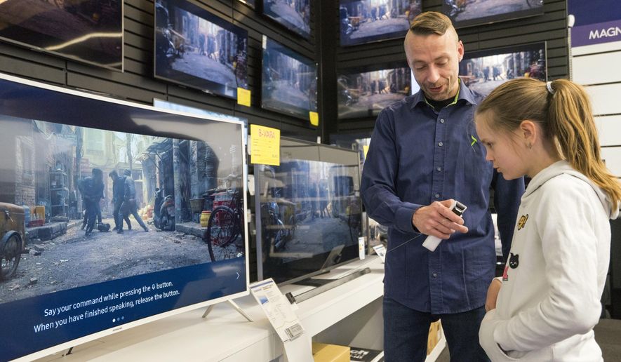 In this photo taken Saturday, April 15, 2017, Salome Sigurjonsdottir, 10, tests a voice-controlled television in an electronics store in Reykjavik. Sales assistant Einar Dadi said none of his TVs understood Icelandic. The revered Icelandic language, seen by many as a source of identity and pride, is being undermined by the widespread use of English both for mass tourism and in the voice-controlled artificial intelligence devices coming into vogue. (AP Photo/Egill Bjarnason)