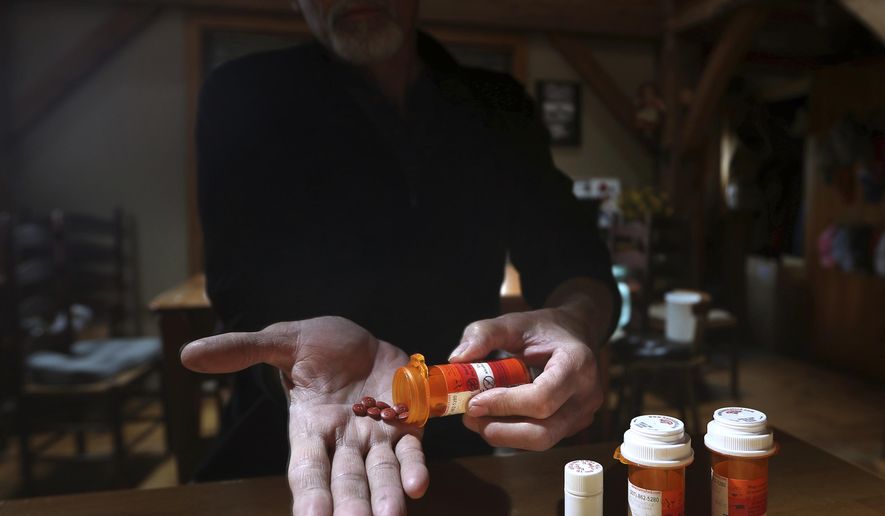 In this Thursday, April 20, 2017, photo, Jeff Bacon shows some of the medication he takes for chronic back pain, in Hampden Maine. Many residents who suffer from debilitating pain fear the state's toughest-in-the-nation opioid prescribing laws. (AP Photo/Robert F. Bukaty)