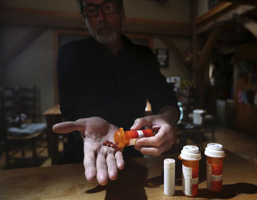 In this Thursday, April 20, 2017, photo, Jeff Bacon shows some of the medication he takes for chronic back pain, in Hampden Maine. Many residents who suffer from debilitating pain fear the state's toughest-in-the-nation opioid prescribing laws. (AP Photo/Robert F. Bukaty)