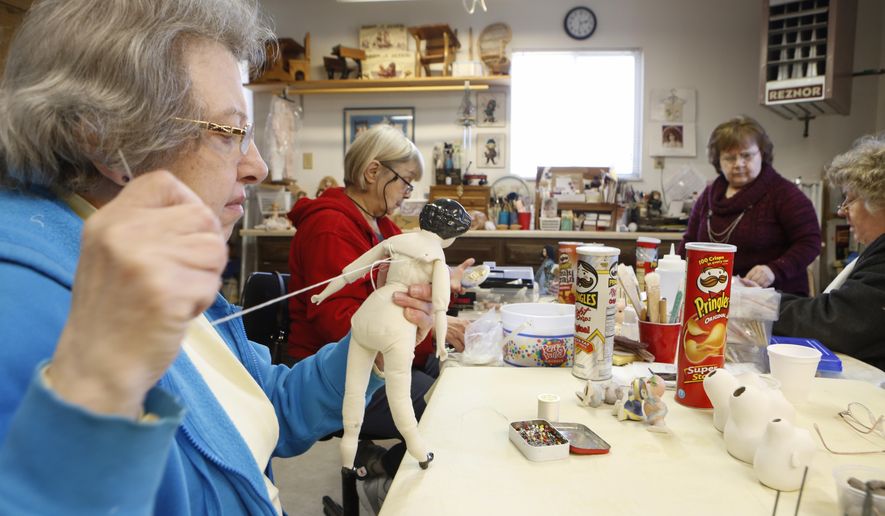 In this March 23, 2017 photo, Mary Boellner, Maumee, left, works on a China head doll at the home of Bev Ostermeyer in Temperance, Mich. Andy Morrison/The Blade via AP)
