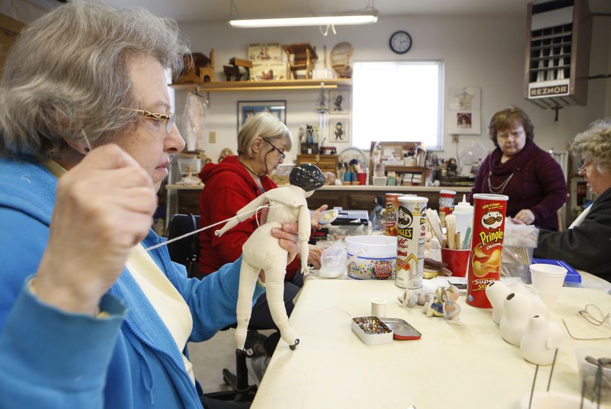 In this March 23, 2017 photo, Mary Boellner, Maumee, left, works on a China head doll at the home of Bev Ostermeyer in Temperance, Mich. Andy Morrison/The Blade via AP)