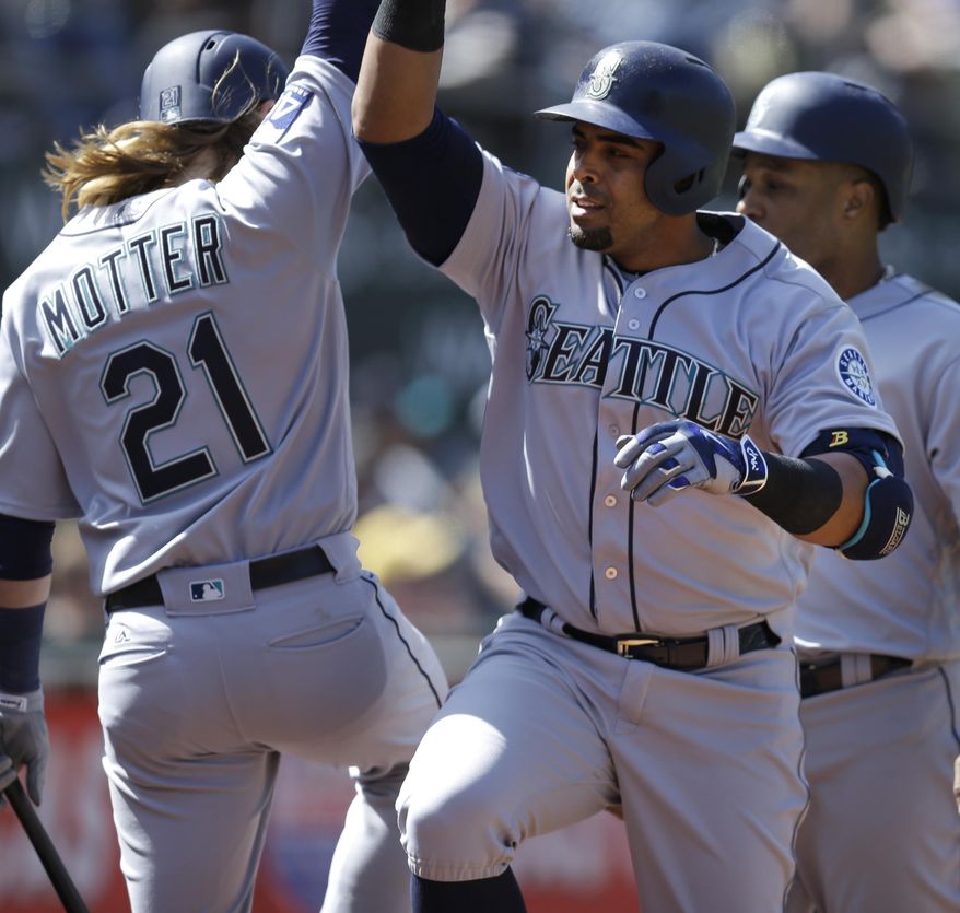 Seattle Mariners&#x27; Nelson Cruz, right, celebrates with Taylor Motter (21) after hitting a three run home run off Oakland Athletics&#x27; Raul Alcantara in the seventh inning of a baseball game, Sunday, April 23, 2017, in Oakland, Calif. (AP Photo/Ben Margot)