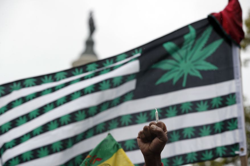 A man holds up a joint during a rally to support the legalization of marijuana on Capitol Hill, Monday, April 24, 2017 in Washington. Smoking pot in public remains illegal everywhere in Washington. (AP Photo/Alex Brandon)