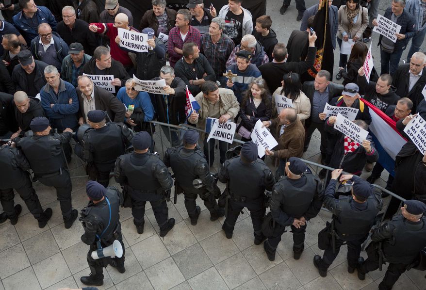Croatian riot police cordon of the area as protesters gather outside the theater building in Split, Croatia, Monday, April 24, 2017. Croatian police have intervened to stop a group of extreme nationalists from disrupting a controversial play that contains scenes of nudity and rape. (AP Photo/Darko Bandic)