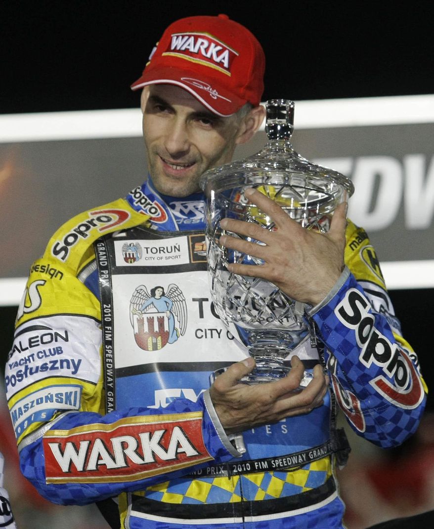FILE - In this file photo taken in Prague, Czech Republic, May 22, 2010, speedway champion Tomasz Gollob of Poland poses with the trophy for winner of the World Speedway Grand Prix. Doctors in Poland say Monday, April 24, 2017 he is in hospital in induced coma and on respirator following an accident in which he injured his spine and chest. (AP Photo/Petr David Josek, file )