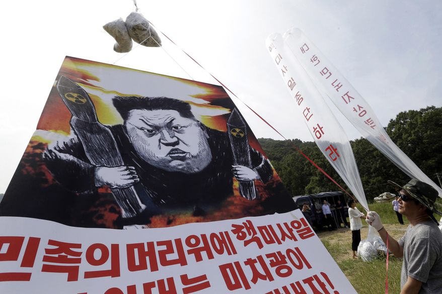 FILE - In this Sept. 15, 2016, file photo, North Korean defectors prepare to release balloons carrying leaflets and a banner denouncing North Korean leader Kim Jong Un for North Korea's latest nuclear test, in Paju, near the border with North Korea, South Korea. North Korea often marks significant dates by displaying military capability, and South Korean officials say there's a chance the country will conduct its sixth nuclear test or its maiden test launch of an ICBM around the founding anniversary of its military on Tuesday, April 25. The letters read "Let's punish Kim Jong-un and stop nuclear test. " (AP Photo/Ahn Young-joon, File)