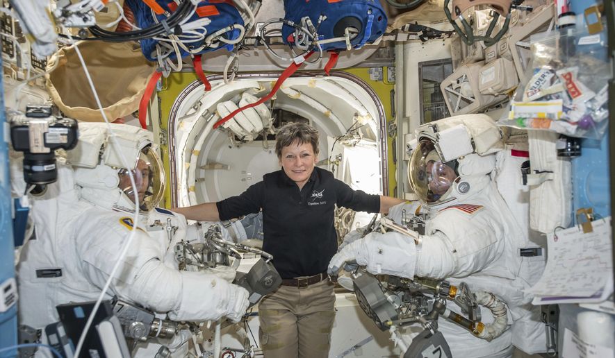 In this Jan. 13, 2017, file photo made available by NASA, astronaut Peggy Whitson, center, floats inside the Quest airlock of the International Space Station with Thomas Pesquet, left, and Shane Kimbrough before their spacewalk. Early Monday, April 24, 2017, the International Space Station commander surpassed the 534-day, two-hour-and-48-minute record set last year by Jeffrey Williams for most accumulated time in orbit by an American.  Whitson already was the world’s most experienced spacewoman and female spacewalker and, at age 57, the oldest woman ever in space. (NASA via AP, File)