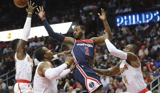 Atlanta Hawks defenders Dennis Schroder, from left, Dwight Howard, and Paul Millsap force Washington Wizards John Wall to pass off under the basket in an NBA playoff basketball game , in Atlanta on Monday, April 24, 2017. Atlanta won 111-101 to even the best-of seven series at 2-2. (Curtis Compton/Atlanta Journal-Constitution via AP)