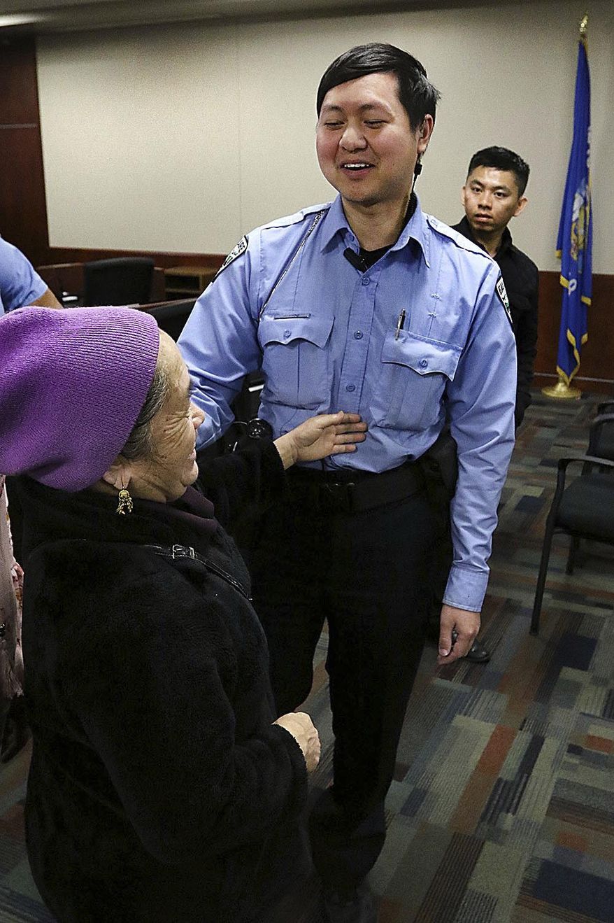 ADVANCE FOR MONDAY, MAY 1 AND THEREAFTER. - In this April 14, 2017, photo, community service officer Jimmy Vang, center, talks with three other Hmong officers at the Eau Claire Law Enforcement Center in Eau Claire, Wis. (Steve Kinderman /The Eau Claire Leader-Telegram via AP)