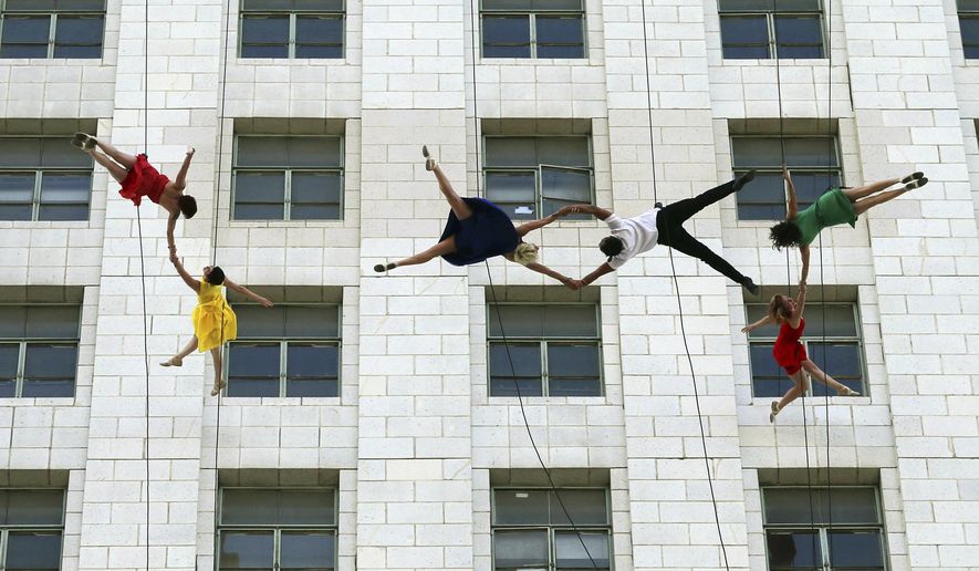 Dancers from Bandaloop aerial dance troupe perform to a medley of songs and dances from the movie "La La Land" off the side of Los Angeles City Hall, during "La La Land Day" festivities Tuesday, April 25, 2017. Mayor Eric Garcetti proclaimed the honor for the musical that claimed six Academy Awards in February. (AP Photo/Reed Saxon)
