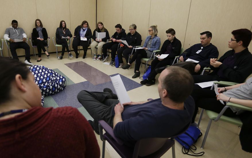 In this Monday, March 13, 2017 photo, students and teachers gather for an all-school meeting called "circle" at Hope Academy in Indianapolis. For teenagers in treatment for addiction, returning to school means resisting offers to get high with old friends. Researchers said these kids do better at special “recovery schools” that use peer pressure in a different way, to support sobriety. Hope Academy in Indianapolis is one of about three dozen recovery schools in the United States. (AP Photo/Michael Conroy)